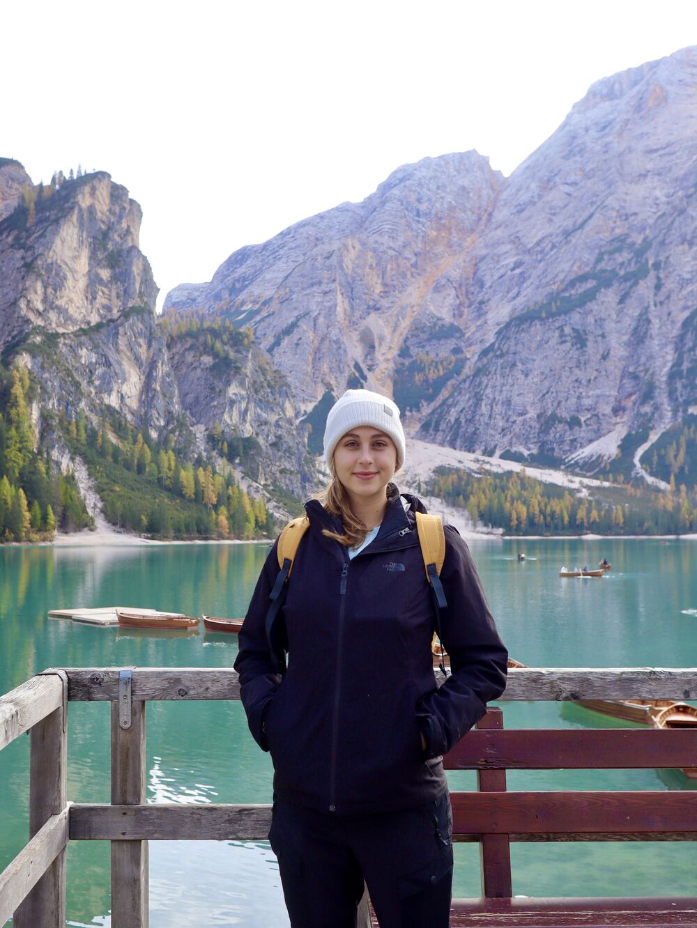 Alexa standing on a dock at an alpine lake in the Dolomites